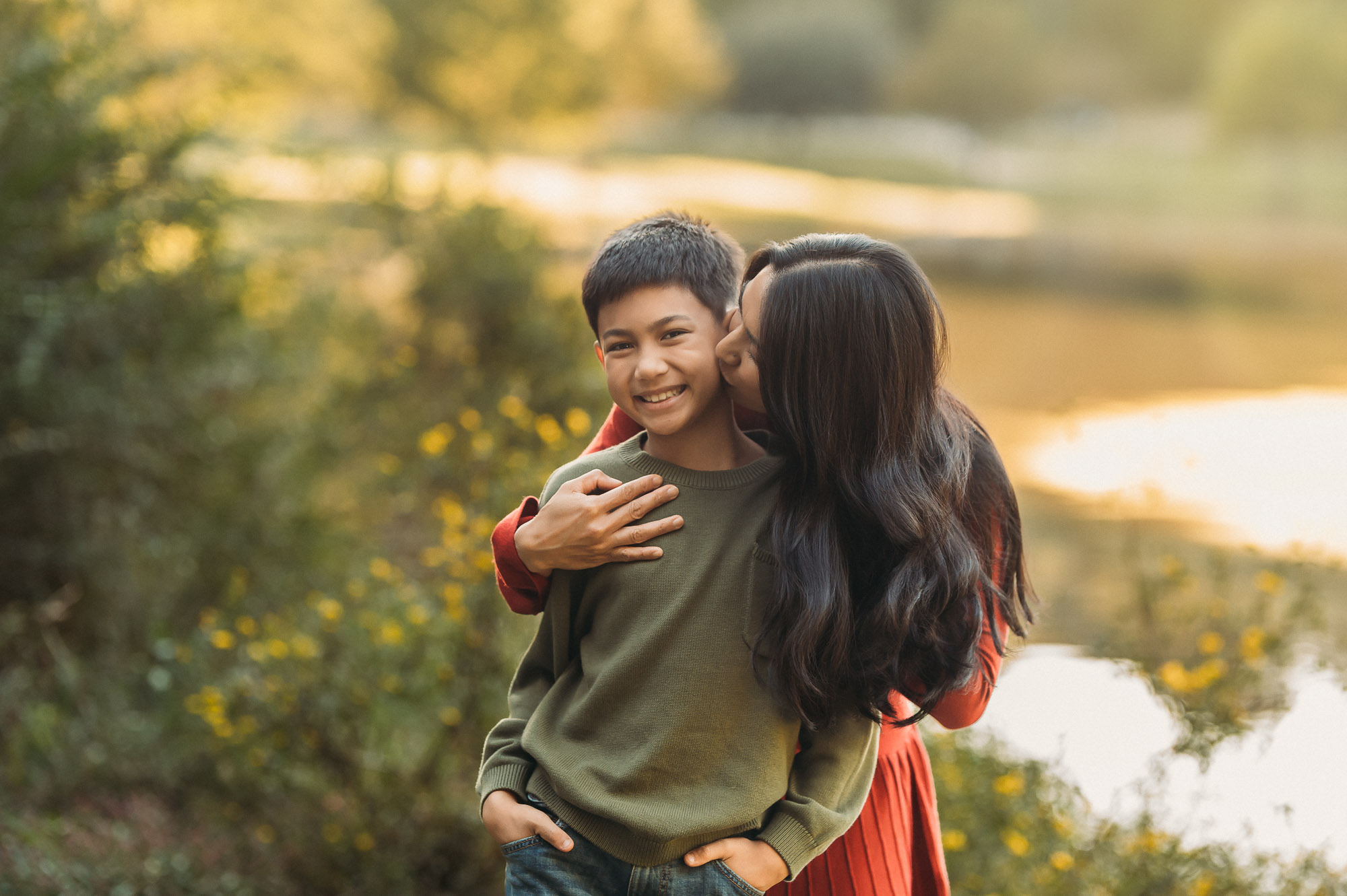 Mom giving son kisses on cheek | Family Session in Tyler TX