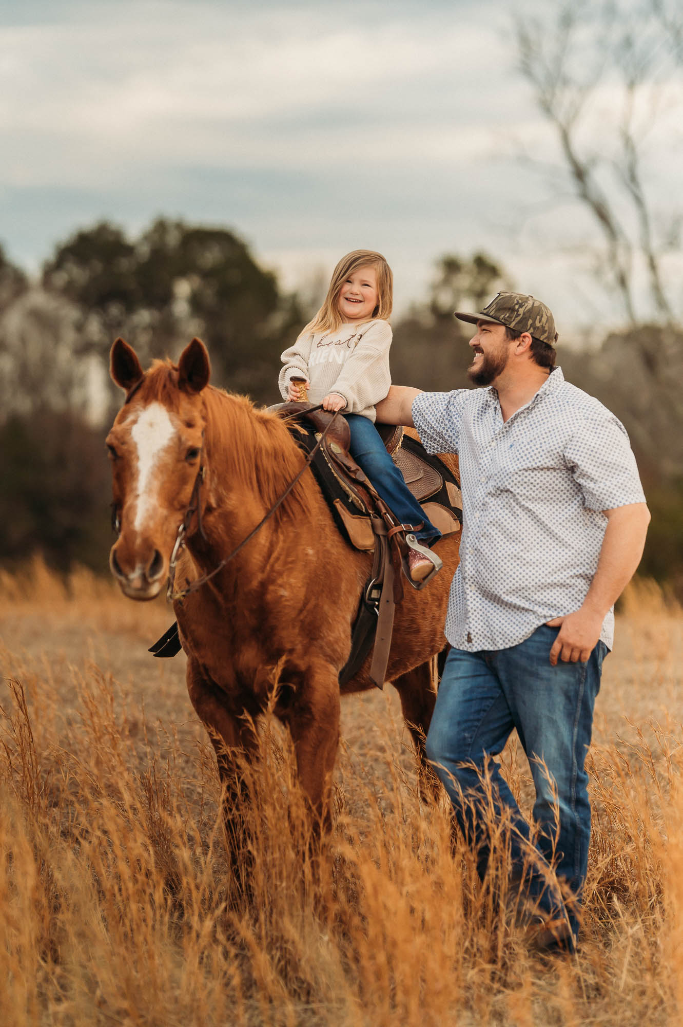 Little girl riding horse in open field with father | East Texas Equestrian Family Photographer