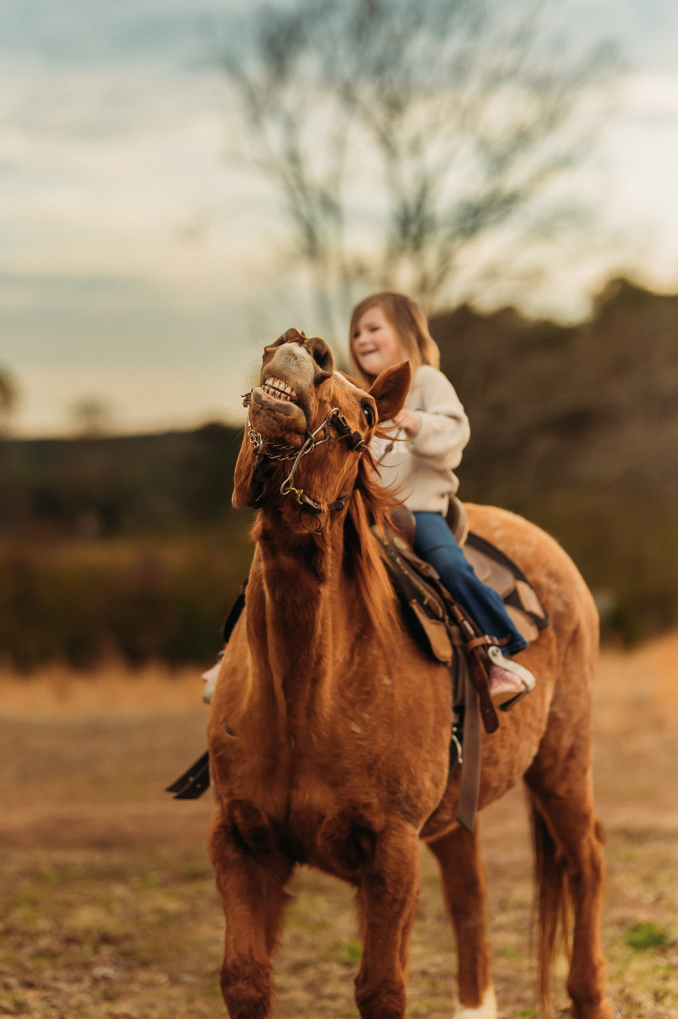 Little girl riding horse and horse making funny face | East Texas Equestrian Family Photographer