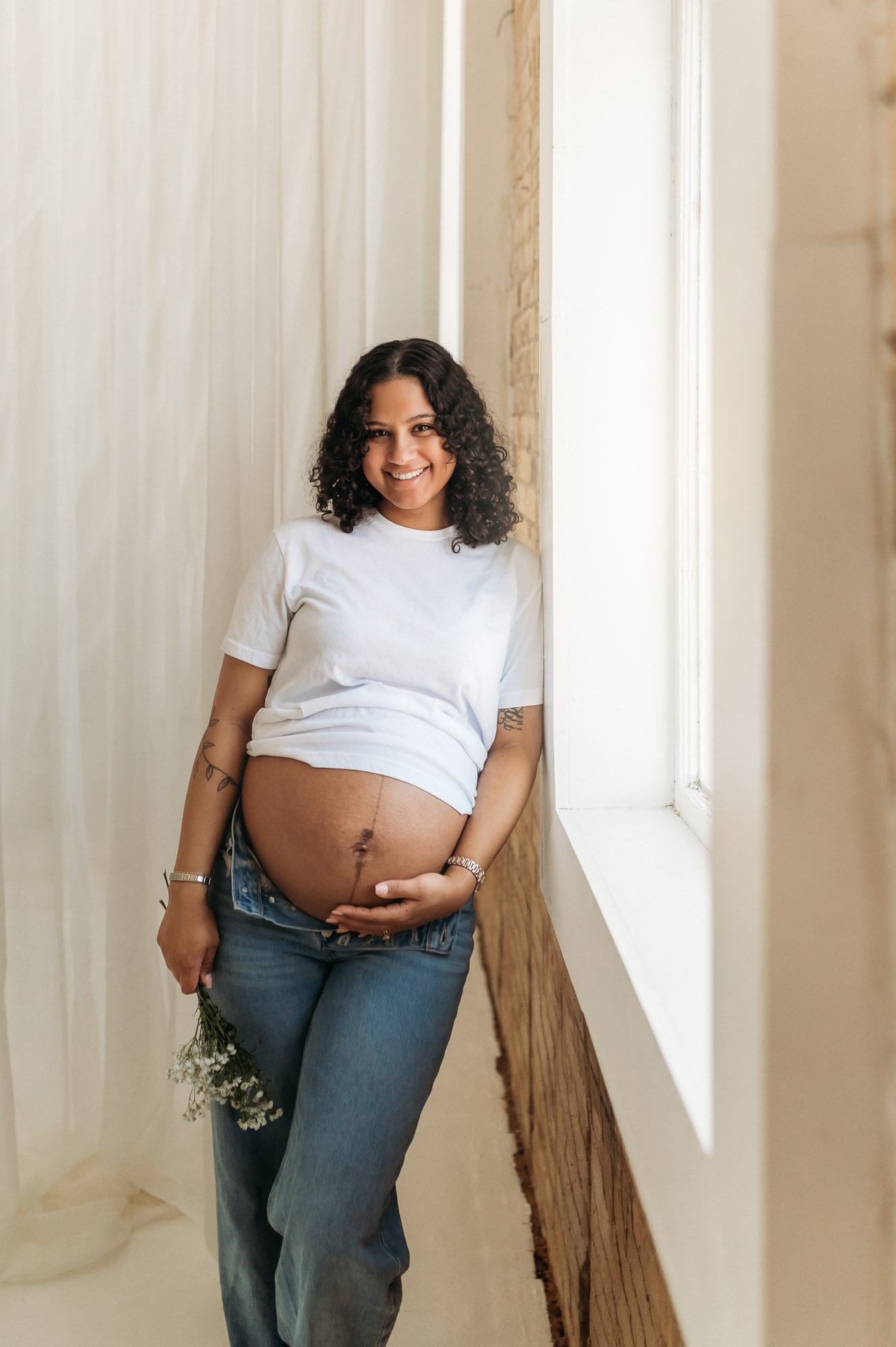 An expecting mom posing in front of a studio window | Lindale Texas Maternity Photographer 