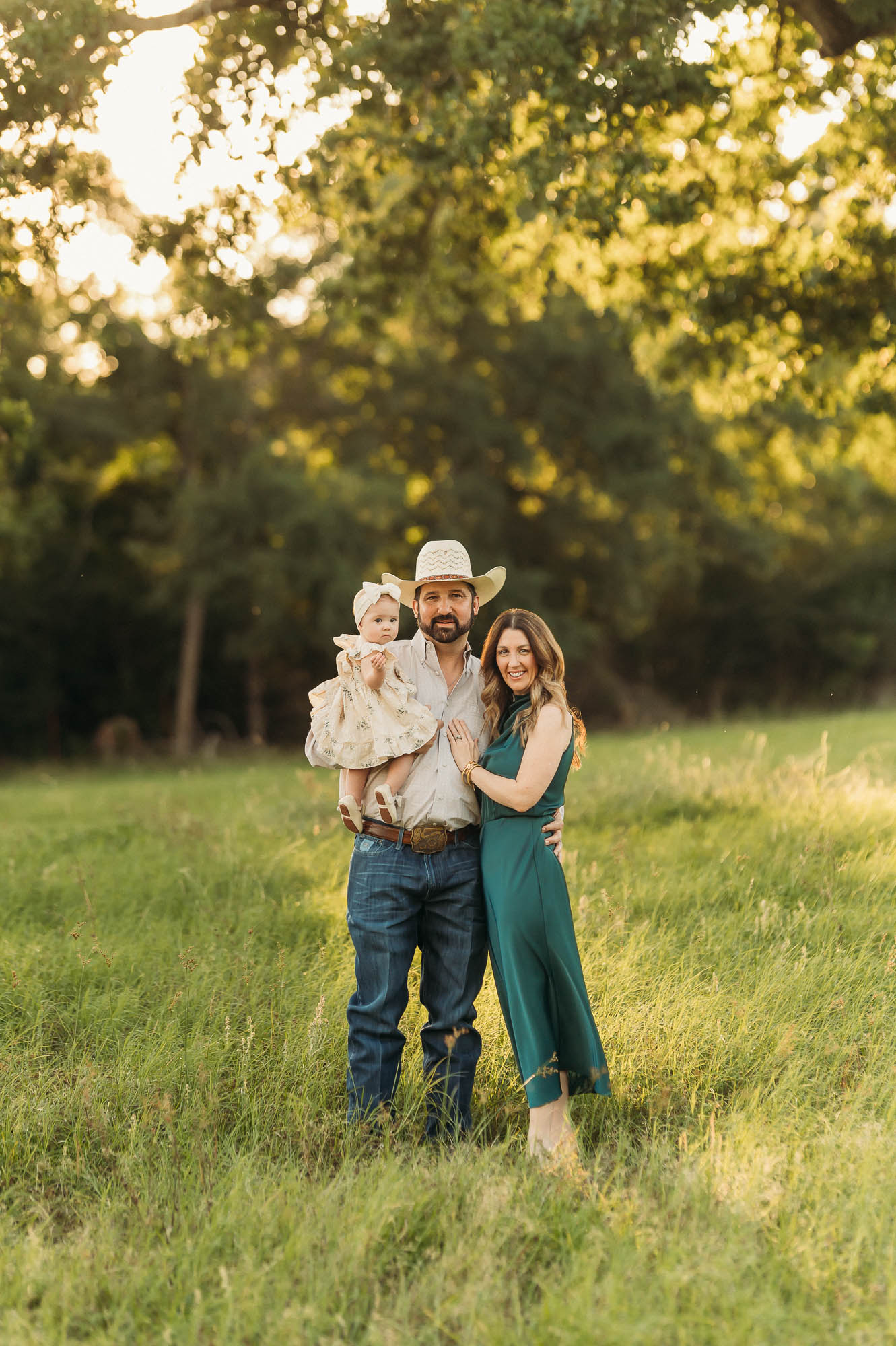 A family in a meadow under a tree with golden light | East Texas Lifestyle Photographer