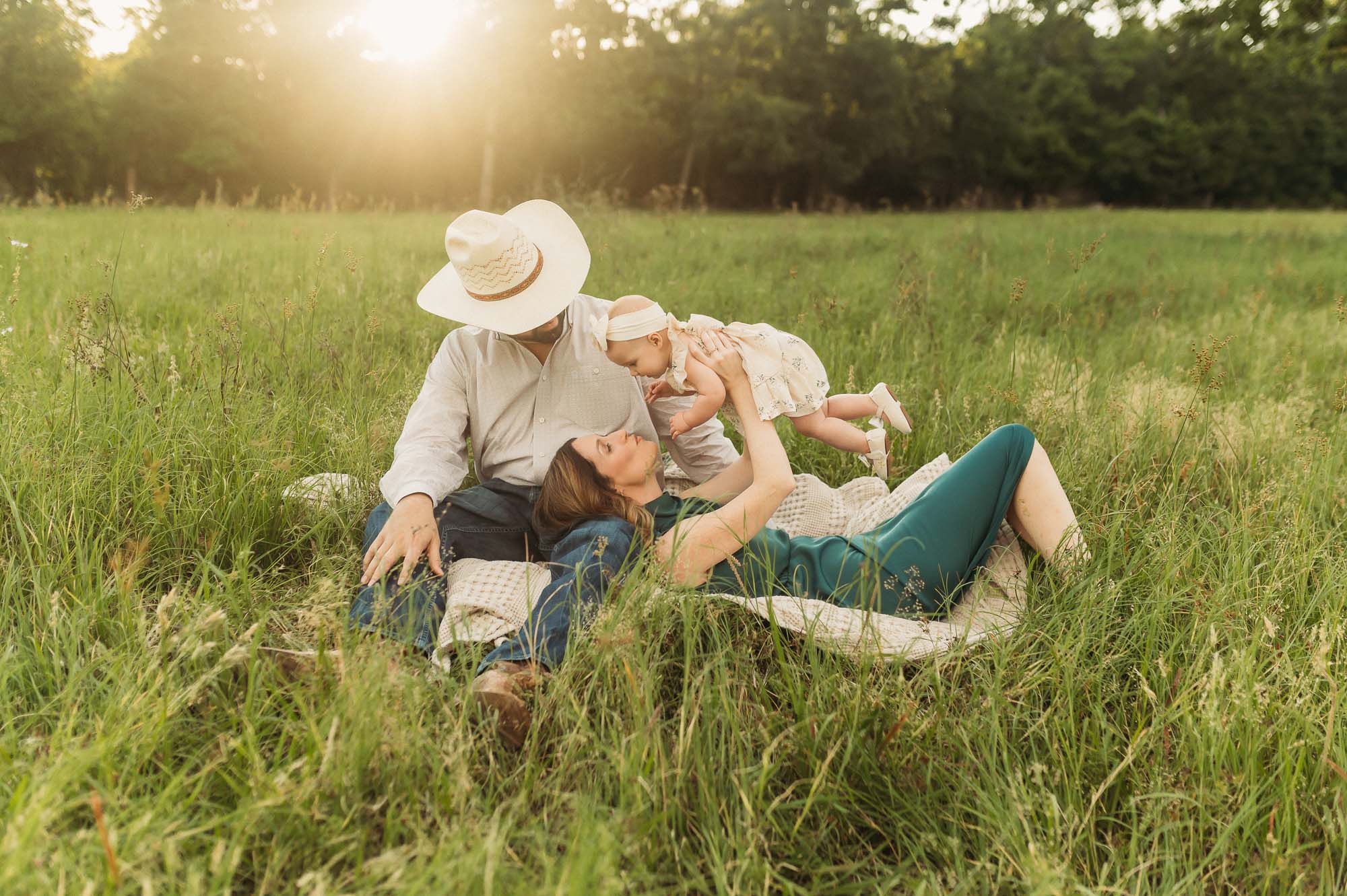a family sitting in a meadow together | East Texas Lifestyle Photographer