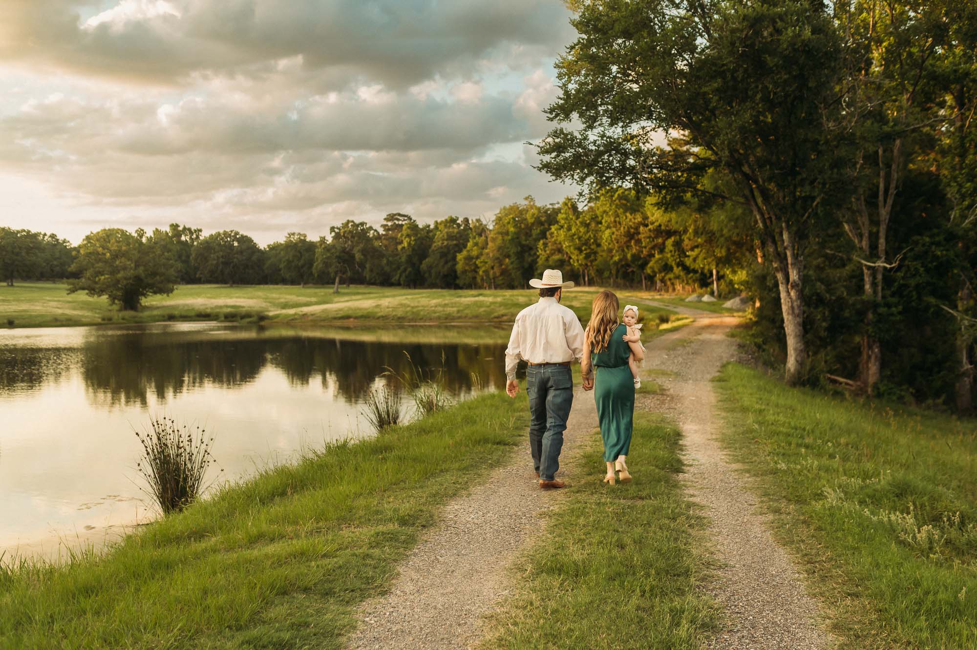 family walking together down a dirt road by a pond | East Texas Lifestyle Photographer