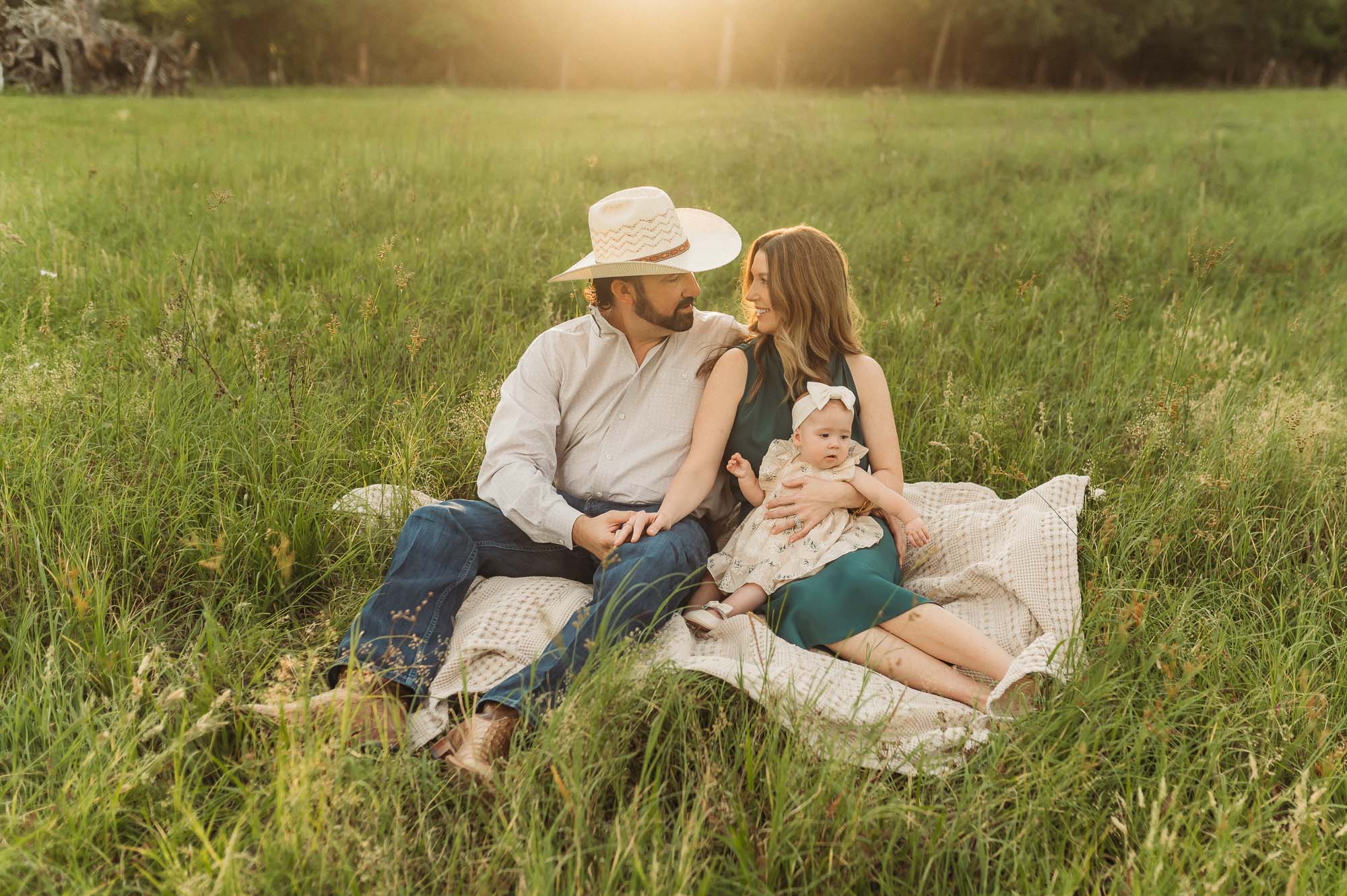 a family sitting in a meadow together | East Texas Lifestyle Photographer
