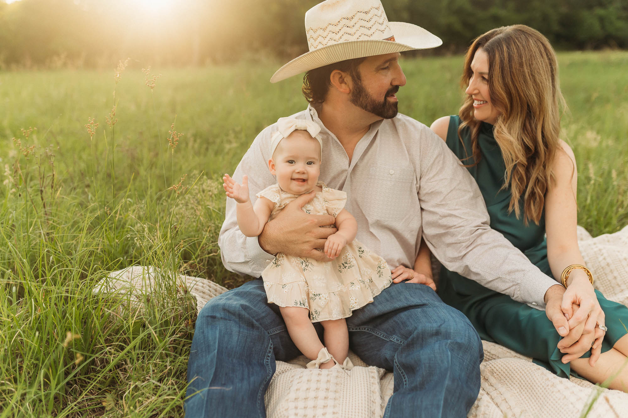 a family sitting in a meadow together | East Texas Lifestyle Photographer