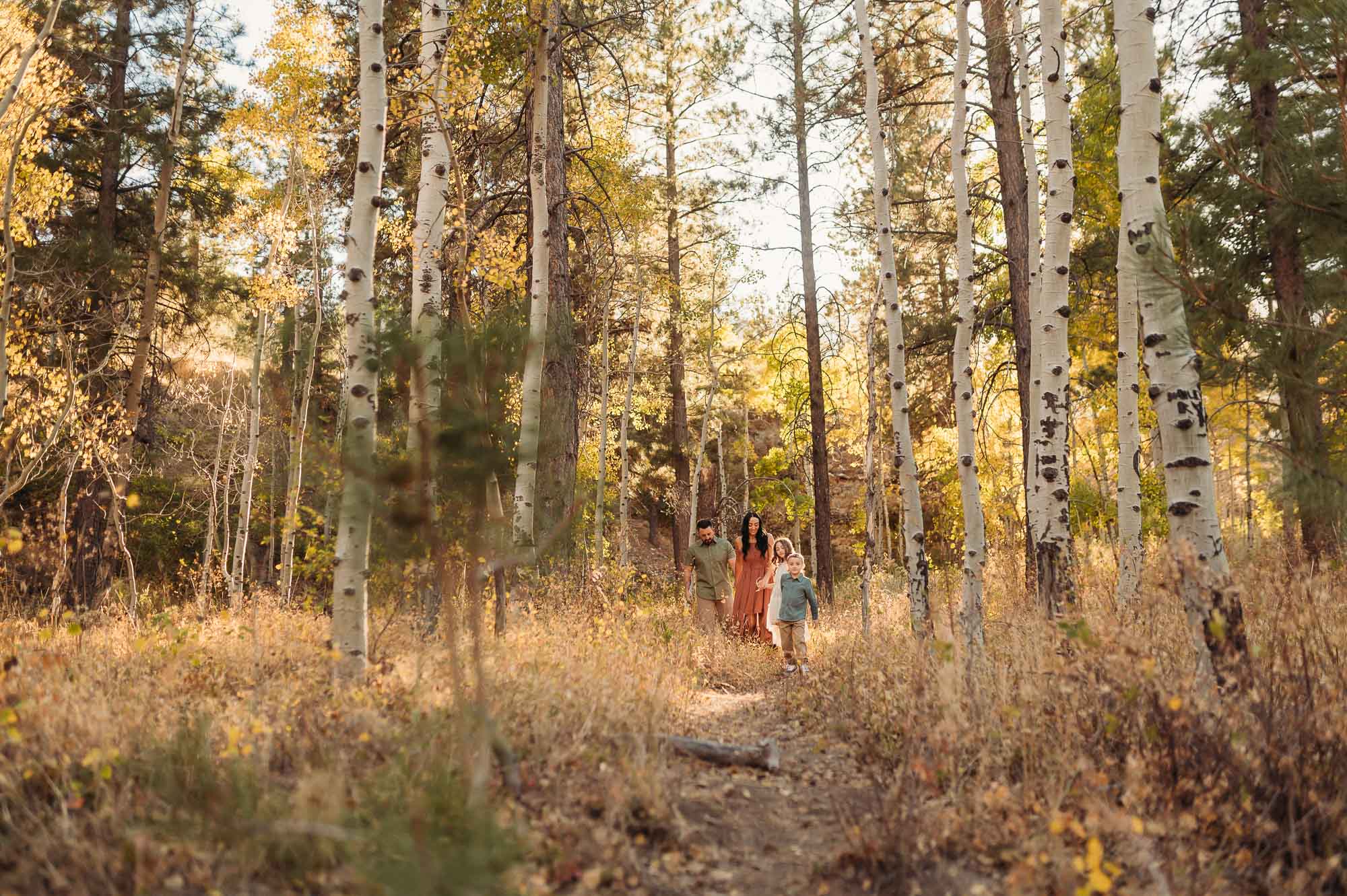 Family walking together in a forest in fall | East Texas Fall Photo Locations