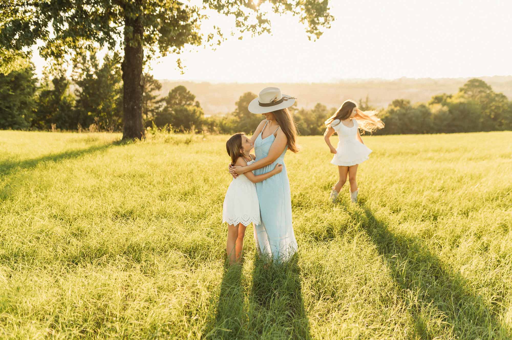 Mother and daughters playing in a grassy meadow | Motherhood Photography Tyler TX