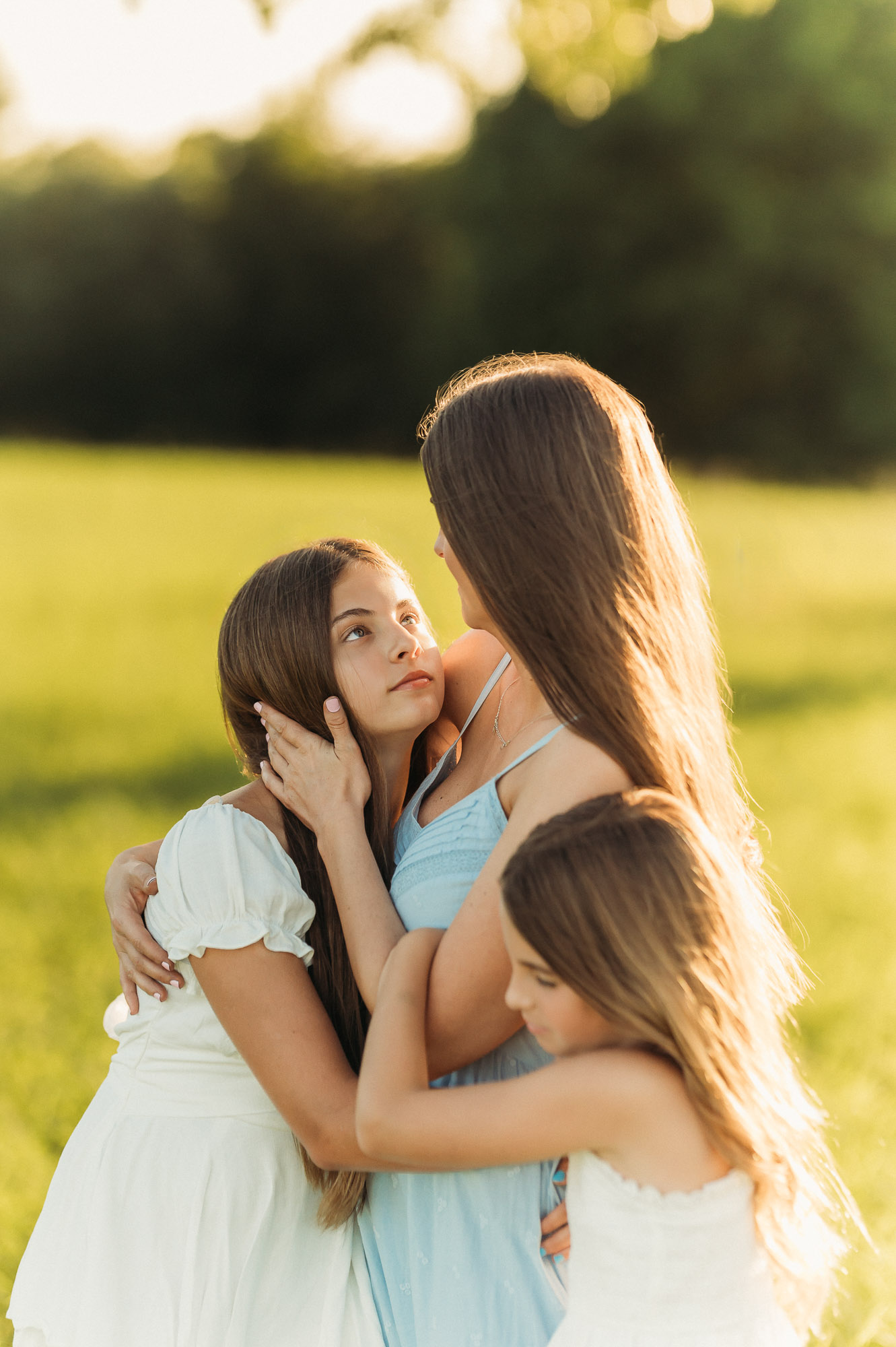 Mother and daughters hugging in a meadow | Motherhood Photography Tyler TX
