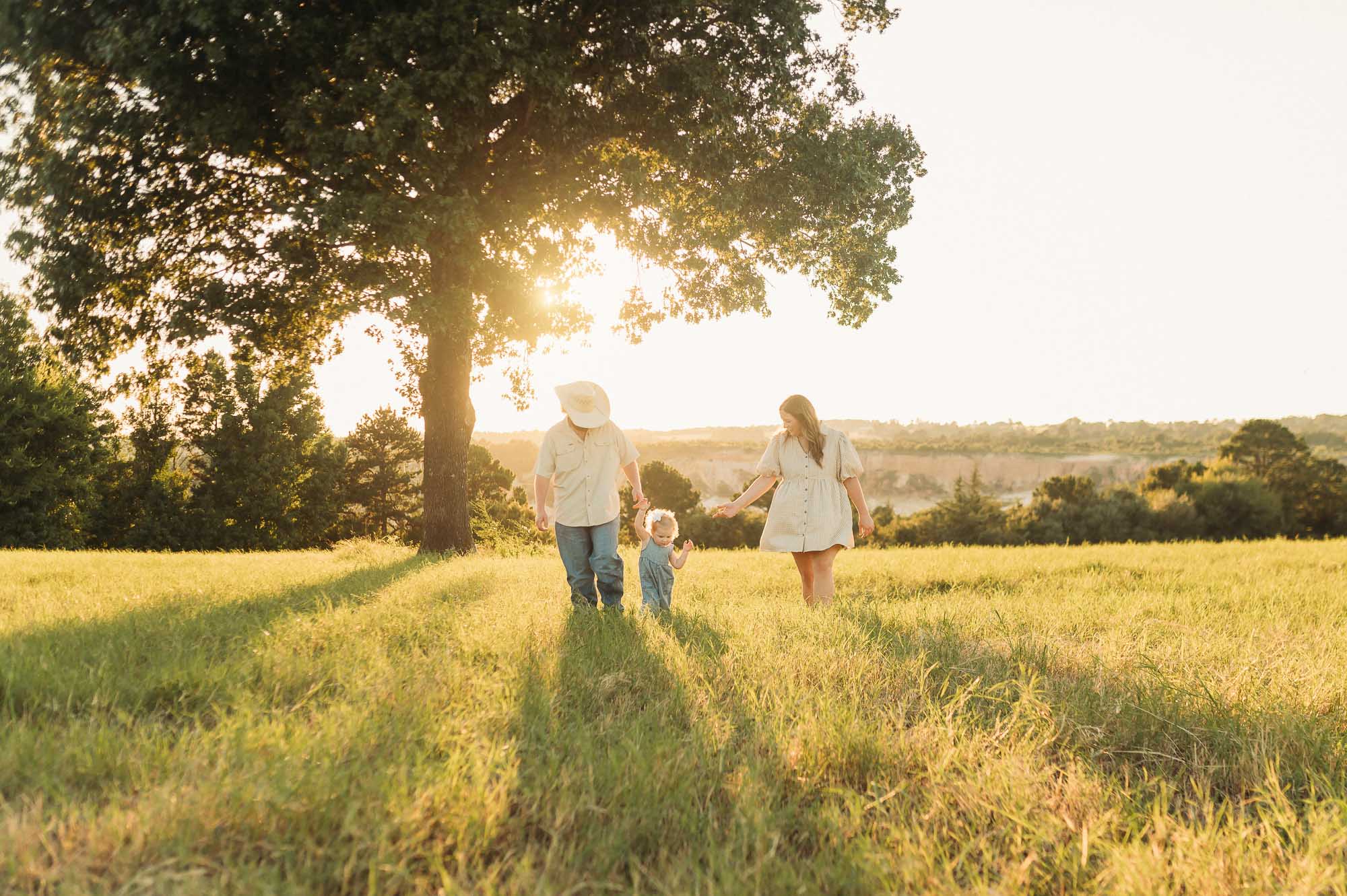 Family walking in a grassy meadow | East Texas Pregnancy Photographer