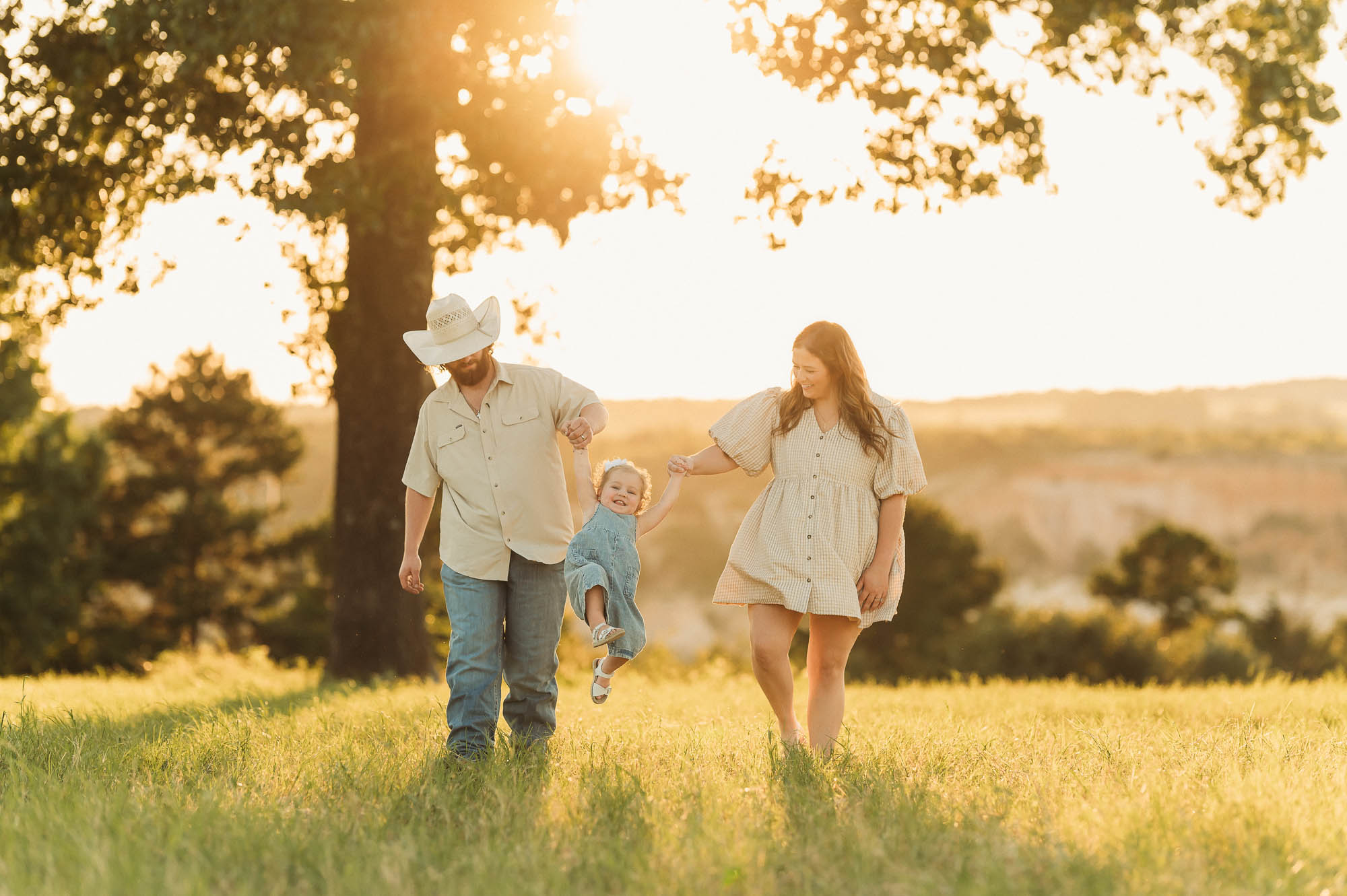 Family walking in a grassy meadow | East Texas Pregnancy Photographer